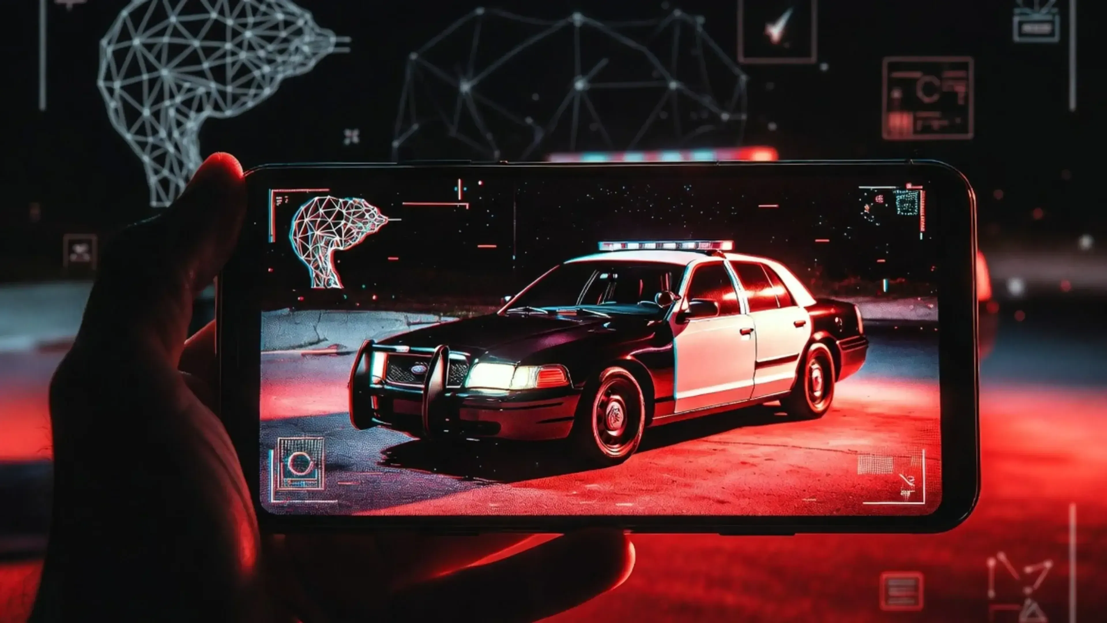 Mano sostiene teléfono mostrando coche patrulla rojo y blanco en pantalla con interfaz digital futurista de fondo.
